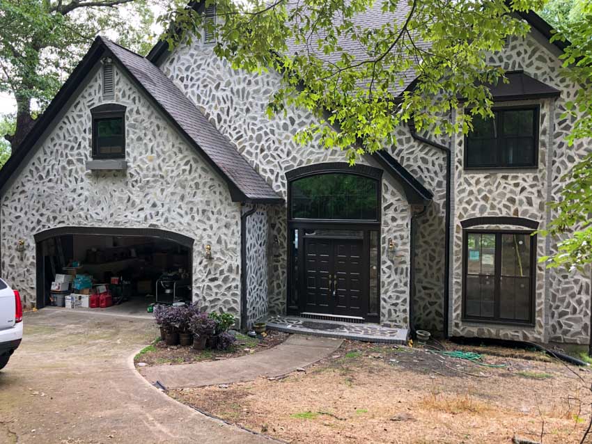 White rain gutter installed on a gray roof of a house