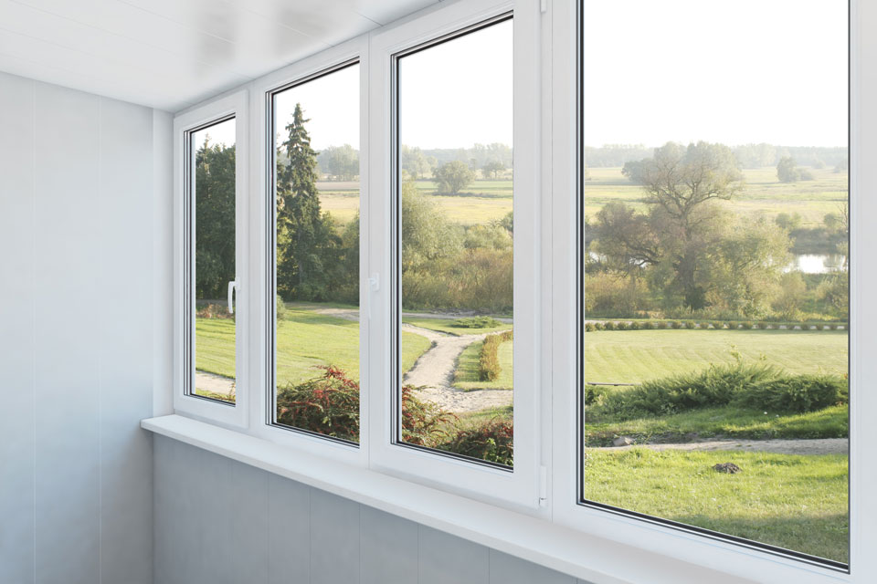 Two professional window installers carefully placing a frame for window replacement