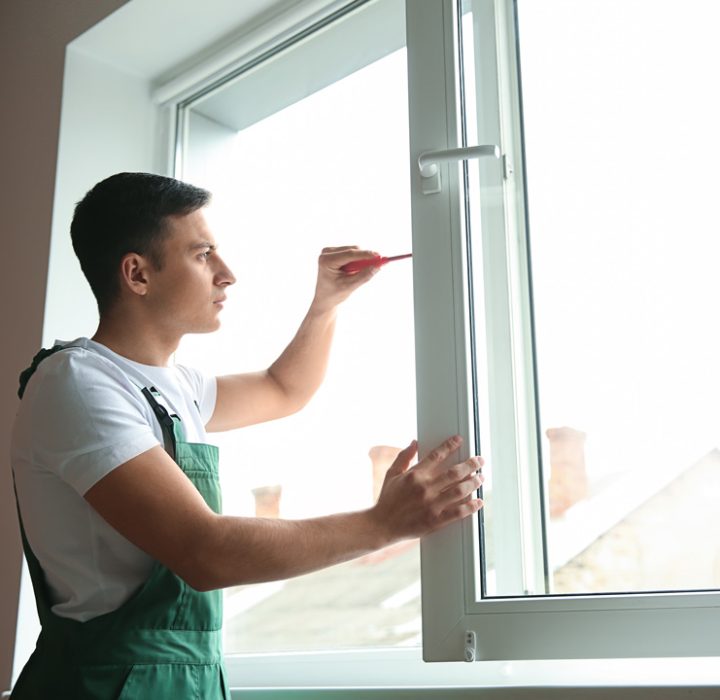 A skilled professional using screwdriver to remove and replace properly the window